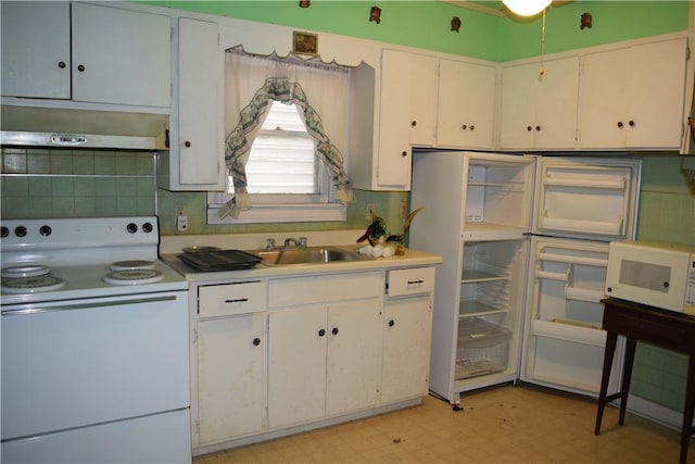 kitchen featuring light floors, light countertops, white appliances, wall chimney exhaust hood, and a sink