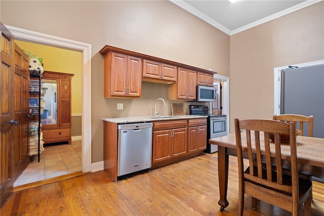 kitchen featuring crown molding, sink, appliances with stainless steel finishes, and light hardwood / wood-style flooring