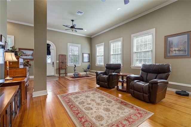 living room featuring ceiling fan, wood-type flooring, and ornamental molding