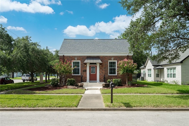 bungalow-style house with central AC unit and a front lawn