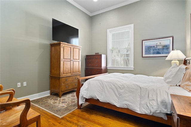 bedroom with wood-type flooring and ornamental molding