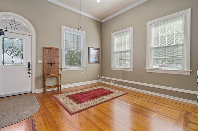 foyer entrance with crown molding and hardwood / wood-style flooring