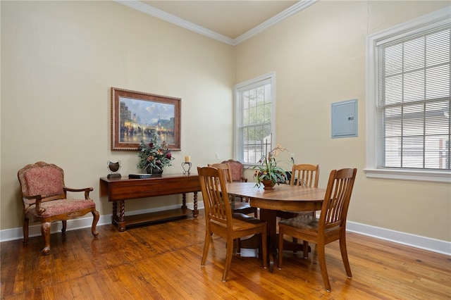 dining area featuring hardwood / wood-style floors, electric panel, and ornamental molding