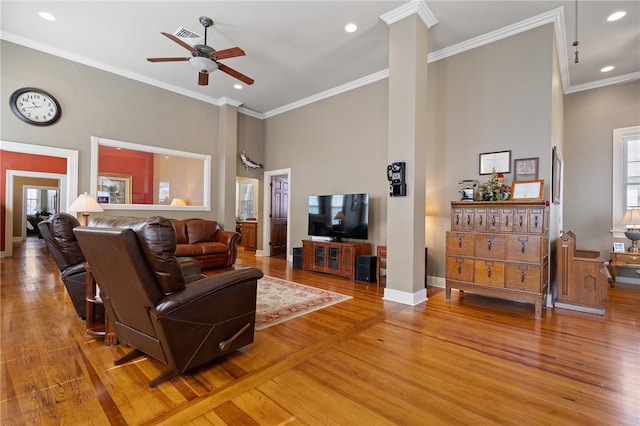 living room featuring hardwood / wood-style floors, a high ceiling, and ornamental molding