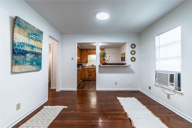 unfurnished living room with cooling unit, sink, and dark hardwood / wood-style floors