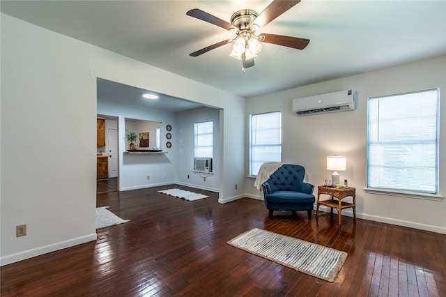 sitting room with ceiling fan, a wall unit AC, dark hardwood / wood-style floors, and cooling unit