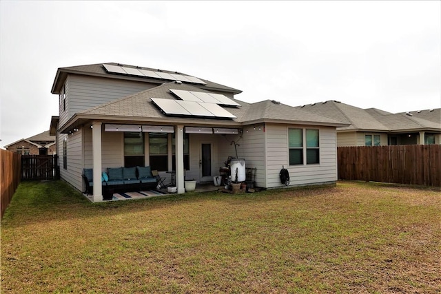 back of property with a yard, an outdoor hangout area, and solar panels