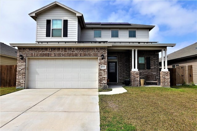 view of front of home with a garage, covered porch, a front yard, and solar panels