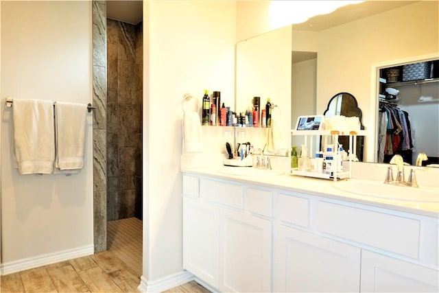 bathroom featuring a tile shower and vanity