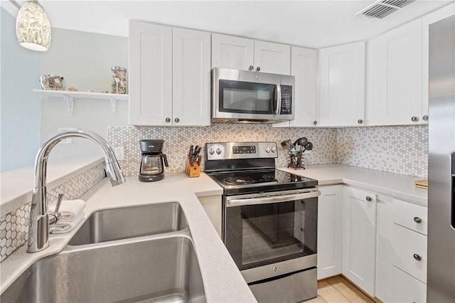 4901 State Highway 361 Unit 126, Port Aransas, TX 78373 - kitchen featuring appliances with stainless steel finishes, light countertops, and white cabinets