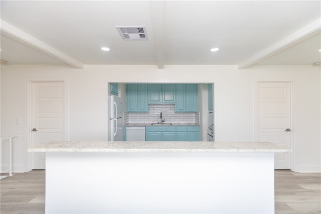 kitchen with decorative backsplash, white appliances, sink, and light hardwood / wood-style flooring