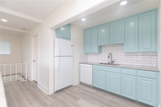 kitchen featuring sink, white appliances, light hardwood / wood-style flooring, blue cabinets, and decorative backsplash