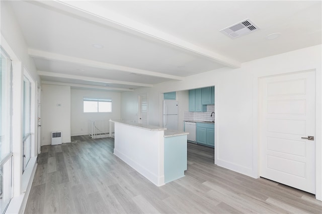 kitchen featuring sink, tasteful backsplash, beamed ceiling, light wood-type flooring, and white appliances