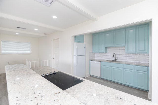 kitchen featuring beam ceiling, light stone countertops, hardwood / wood-style floors, sink, and white appliances