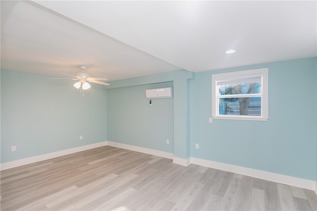 unfurnished room featuring an AC wall unit, ceiling fan, and light hardwood / wood-style floors