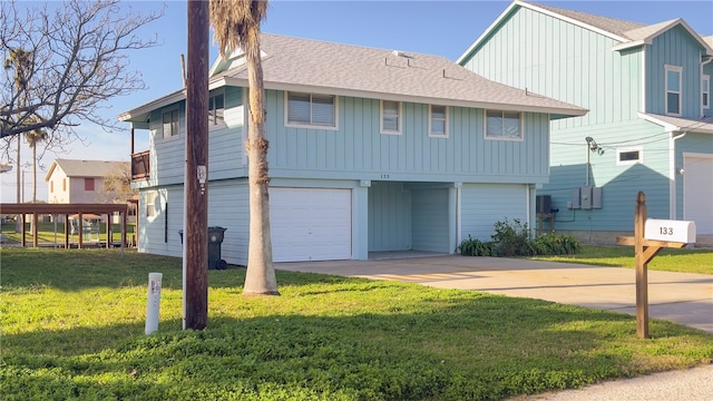 view of front of property with a garage, a front yard, and a carport