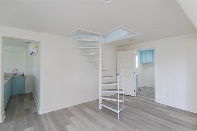 interior space with a wall mounted AC and light hardwood / wood-style flooring