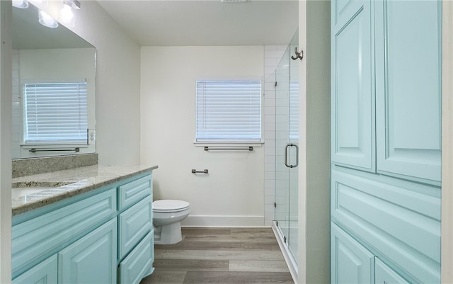 bathroom featuring walk in shower, wood-type flooring, toilet, and vanity