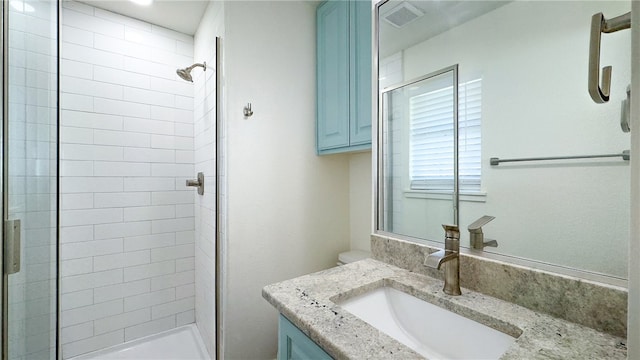 bathroom featuring vanity and a shower with door