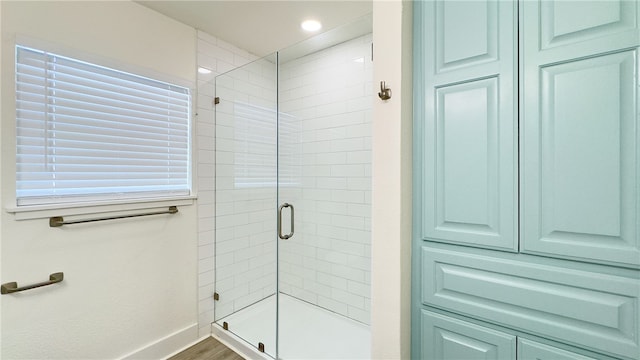 bathroom with an enclosed shower and wood-type flooring