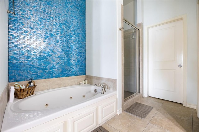 full bath featuring a whirlpool tub, tile patterned flooring, and a shower stall