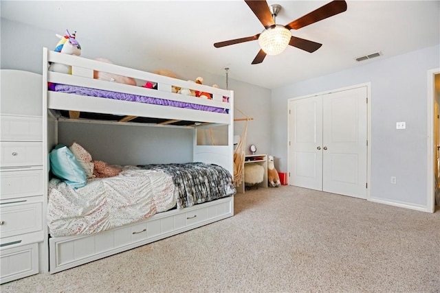 carpeted bedroom featuring baseboards, a closet, visible vents, and a ceiling fan