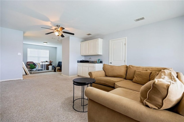 living room with visible vents, indoor wet bar, a ceiling fan, and baseboards