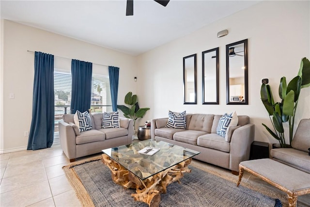 living area with light tile patterned floors, a ceiling fan, and baseboards