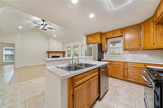 kitchen featuring light countertops, light tile patterned floors, a sink, a ceiling fan, and appliances with stainless steel finishes