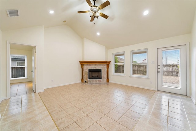 unfurnished living room with lofted ceiling, light tile patterned flooring, visible vents, a ceiling fan, and a tile fireplace