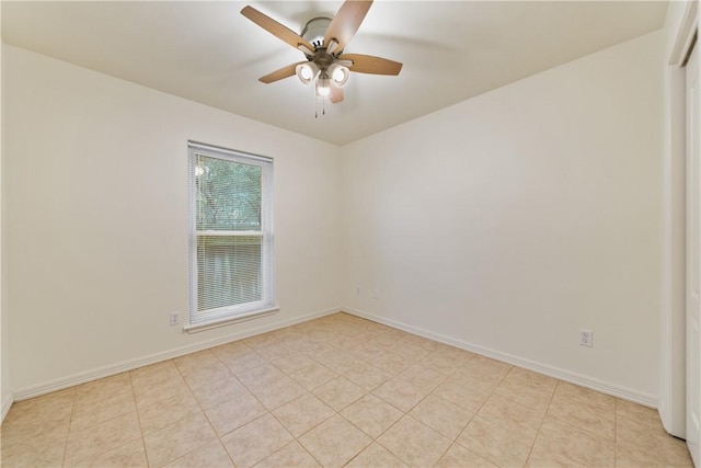 empty room featuring baseboards, light tile patterned floors, and a ceiling fan
