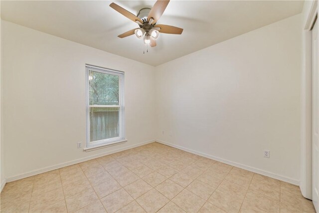 unfurnished room featuring baseboards, ceiling fan, and light tile patterned flooring