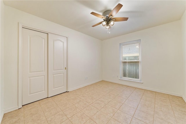 unfurnished bedroom featuring light tile patterned flooring, baseboards, a closet, and ceiling fan
