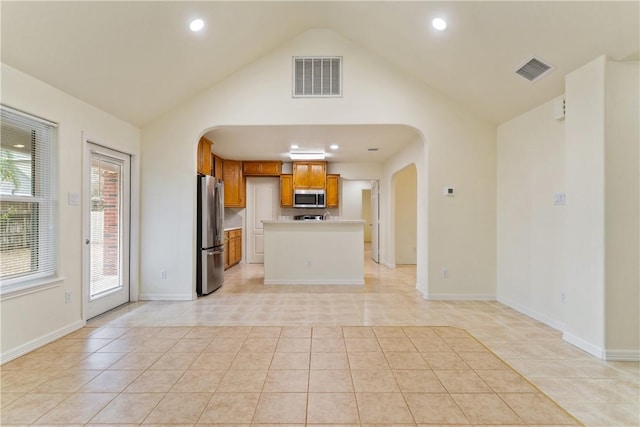 kitchen featuring visible vents, arched walkways, appliances with stainless steel finishes, and light tile patterned floors