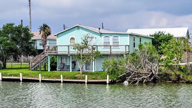 619 Copano Cove Rd, Rockport, TX 78382 - rear view of house with a deck with water view, stairs, and a lawn
