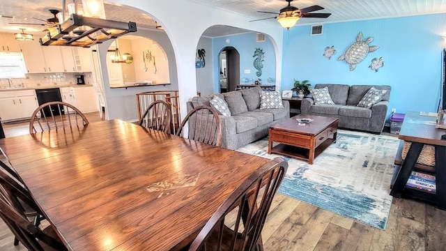 619 Copano Cove Rd, Rockport, TX 78382 - dining area with ceiling fan, arched walkways, light wood-style floors, and a chandelier