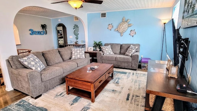 619 Copano Cove Rd, Rockport, TX 78382 - living area with arched walkways, a ceiling fan, ornamental molding, and wood finished floors