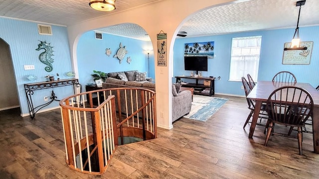 619 Copano Cove Rd, Rockport, TX 78382 - dining space featuring crown molding, arched walkways, and wood-type flooring