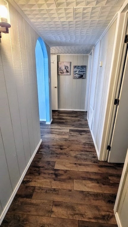 619 Copano Cove Rd, Rockport, TX 78382 - hallway with arched walkways, dark wood-style flooring, wood walls, and crown molding