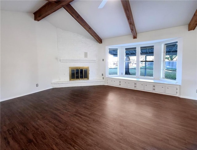 unfurnished living room featuring ceiling fan, dark wood-type flooring, lofted ceiling with beams, and a fireplace