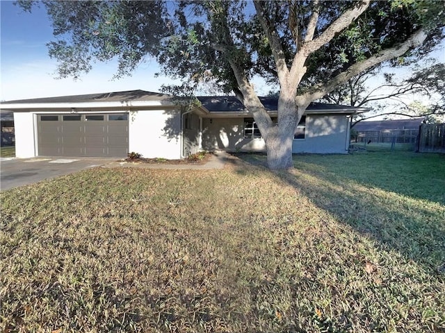 ranch-style house featuring a garage and a front lawn