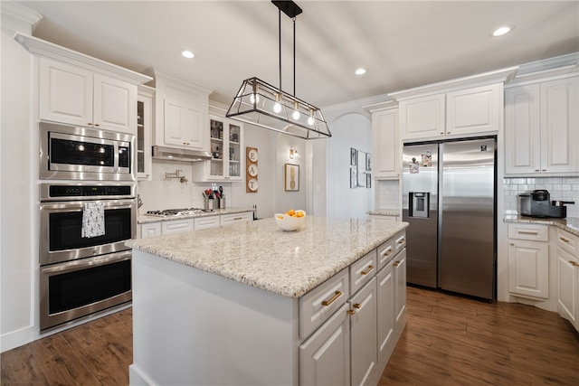 kitchen with appliances with stainless steel finishes, white cabinetry, and a kitchen island