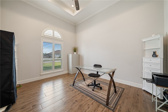 office area featuring dark wood-style floors, baseboards, ornamental molding, and a raised ceiling