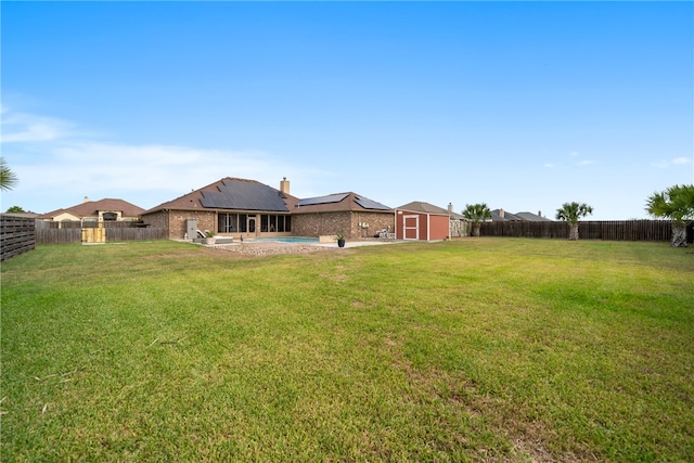 view of yard featuring a patio area, a fenced backyard, an outdoor structure, and a storage unit