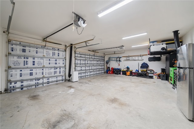 garage featuring a garage door opener and freestanding refrigerator