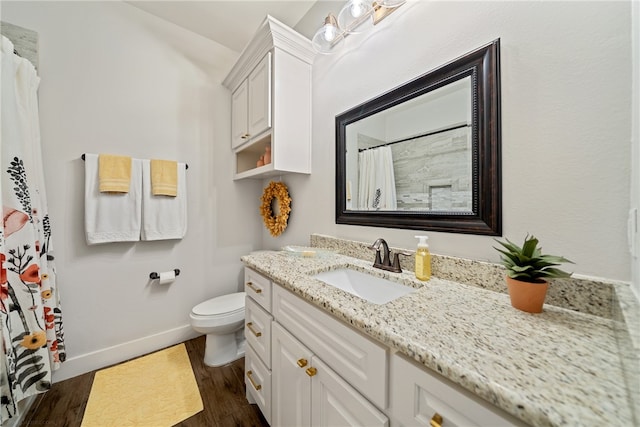 full bathroom featuring toilet, wood finished floors, vanity, and baseboards