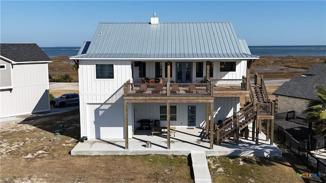 back of house with a patio and a water view