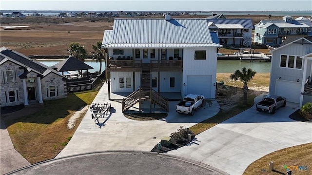 view of front of home featuring a garage, a balcony, and a water view