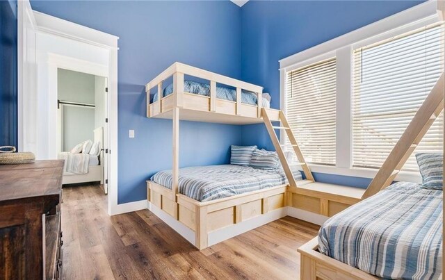 bedroom with ceiling fan, wood-type flooring, and a barn door