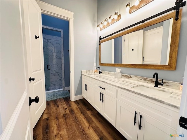 bathroom featuring wood-type flooring, an enclosed shower, and vanity